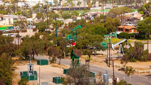 View of green oil wells in a residential neighborhood in California.