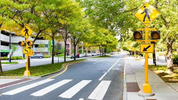 Striped crosswalk with yellow pedestrian crossing signs and grassy pedestrian island in Boston, Massachusetts