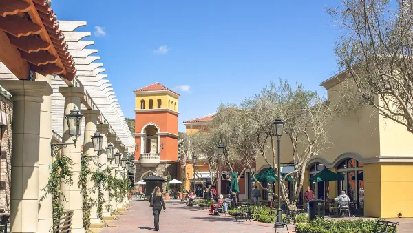 Suburban outdoor mall in muted colors with decorative tower.