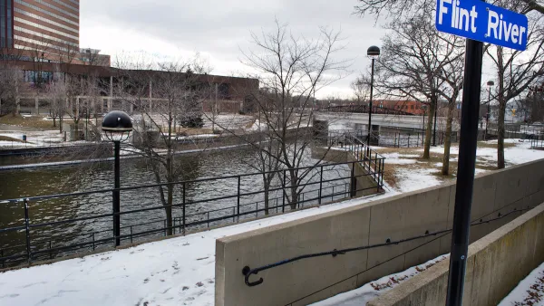 Flint River with blue sign on post in winter.