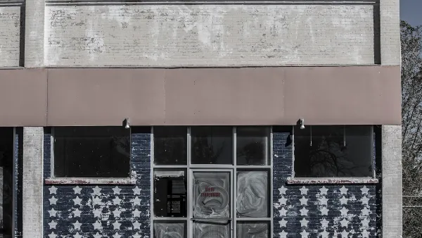 Faded image of vacant storefront in rural area with American flag stars painteind on windows.