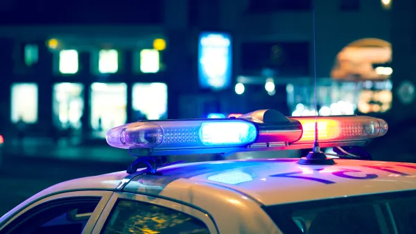 Nighttime view of blue and red lights on top of a white police car.
