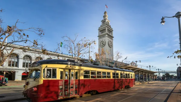Red and yellow vintage streetcar in front of San Francisco Ferry Building.