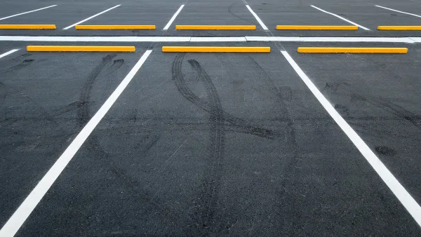 Empty asphalt parking lot with white lines.