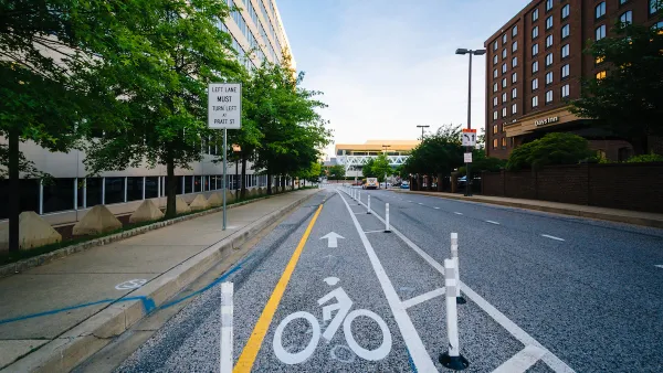 Bike lane protected by plastic delineators on street in downtown Baltimore, Maryland.