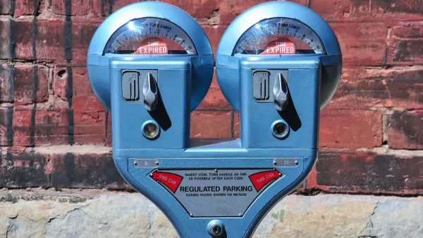 Close-up of old-fashioned blue double parking meter against red brick wall.