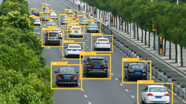 View of traffic on a multilane highway with superimposed yellow triangles identifying vehicles.