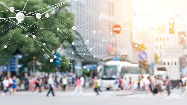 Blurred image of pedestrians on busy street with 'smart city' network rendering superimposed.