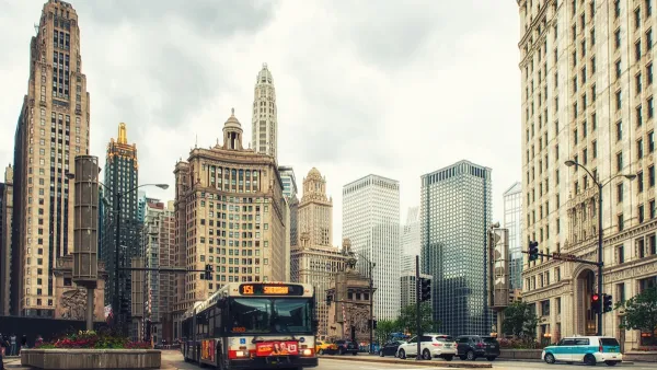Public transit bus on Chicago street with tall historic buildings in background.