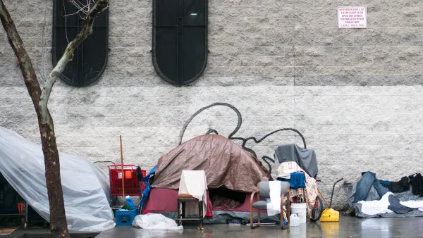 Tent covered with tarp with bike and other objects on sidewalk in Skid Row, downtown Los Angeles