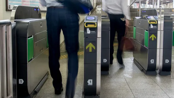 People entering modern fare gates in subway station.