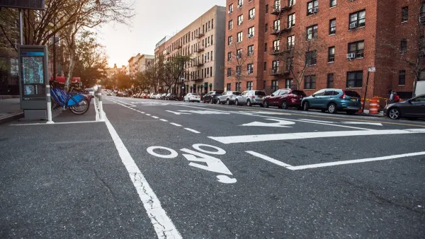 Low view of bike lane on New York City street with bike share station next to curb.