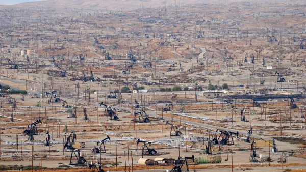 View of vast oil drilling field with black oil derricks near Bakersfield, California