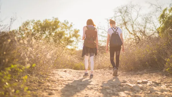 Two young women hiking at golden hour.