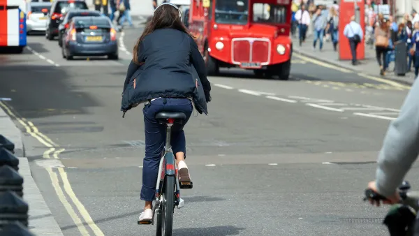 Woman rides a bike on street in London, UK.