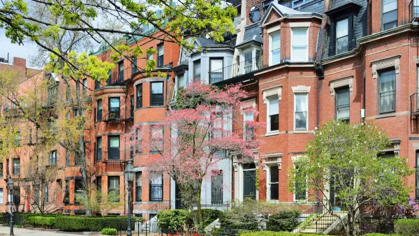 Brick brownstone homes in Back Bay, Boston with green hedges in front.