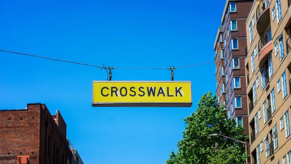Yellow CROSSWALK sign hanging above a street in downtown Seattle, Washington.