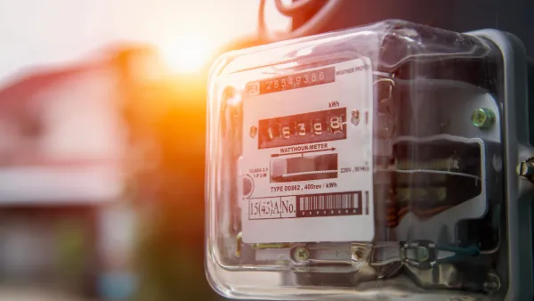 Close-up of electricity meter on house with sunset light in background.