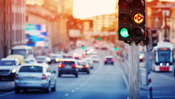 Traffic light with blurred cars and streetcar in background.