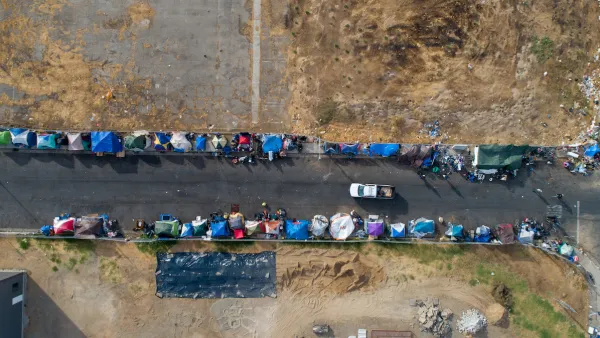 Aerial bird's eye view of unhoused encampment along roadside in Sacramento, California.