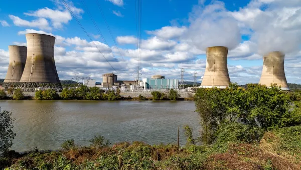 View of Three Mile Island nuclear power plant with four reactor towers on a sunny day.