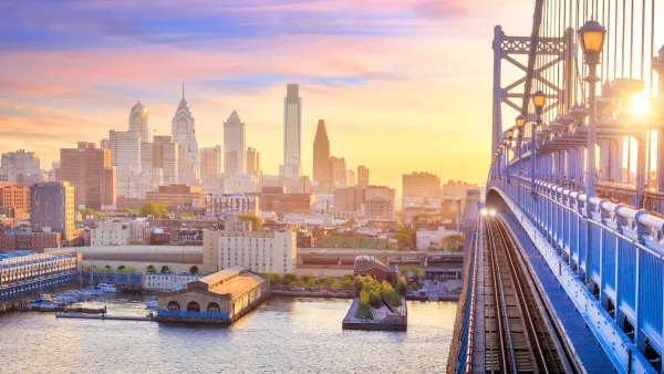 Phialdelphia skyline at sunset with close-up of bridge in foreground.