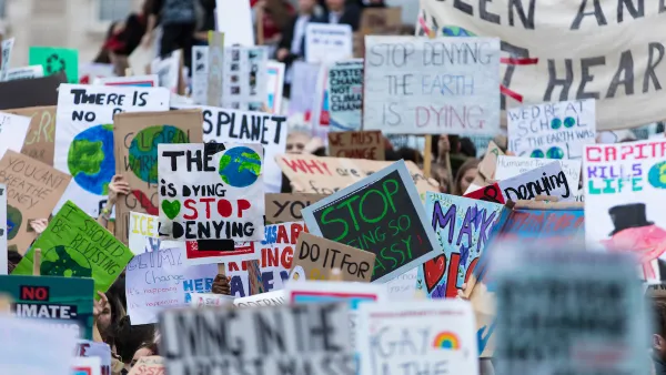 Close-up on dozens of anti-climate change signs at protest with people not visible.