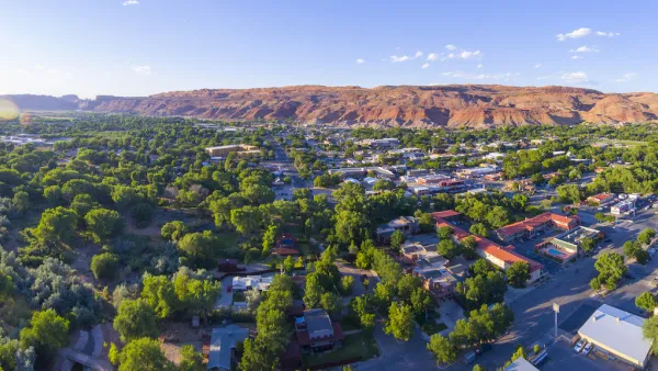 Aerial view of Moab, Utah with red mountains in background.