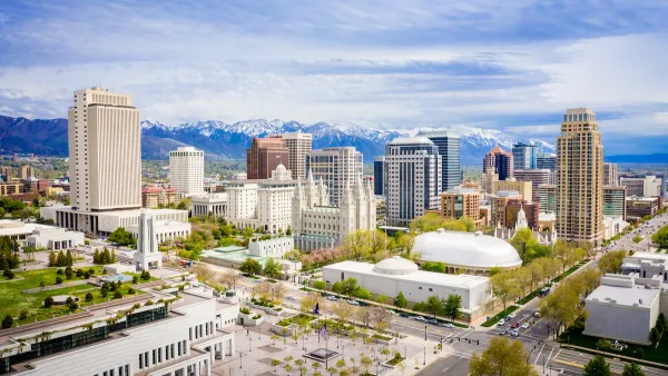 Aerial view of downtown Salt Lake City, Utah with snow-capped mountains in background.