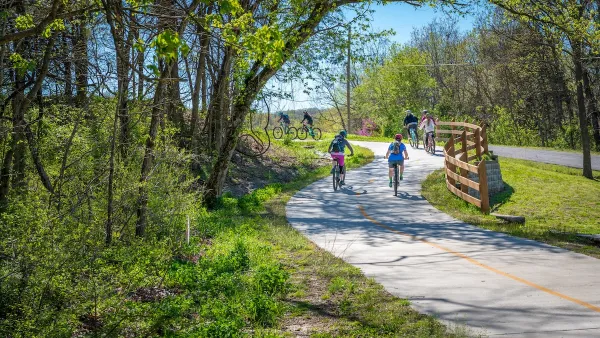 People biking on paved bike trail in Arkansas.