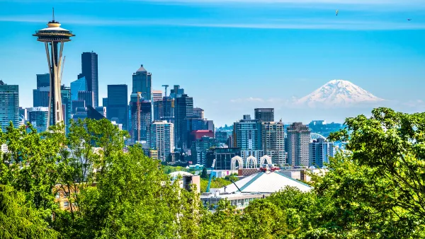 View of Seattle skyline on clear sunny day with Space Needle on left and Mount Rainier in the background.