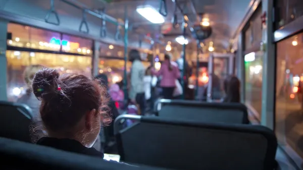 View of passengers on transit bus at night.