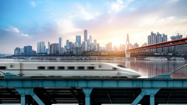 High-speed rail train passing on bridge with Chongqing, China skyline in background.