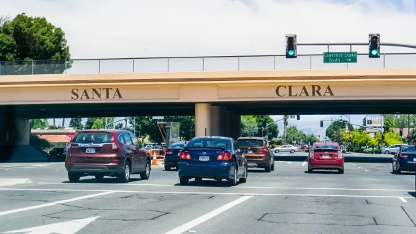 Cars passing under 101 freeway overpass with SANTA CLARA in large letters on the overpass