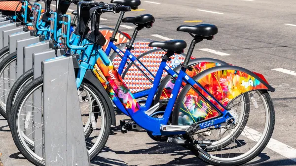 Bay Wheels bike share station full of colorful parked bikes on San Francisco street.
