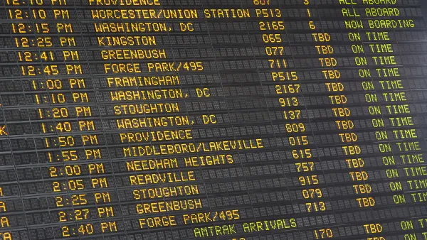 Close-up of old-fashioned trains departure board with yellow text on black background in Boston, Massachusetts train station.