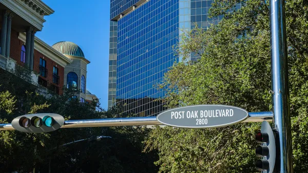 "Post Oak Boulevard" street sign in downtown Houston, Texas with glass high-rises in background.