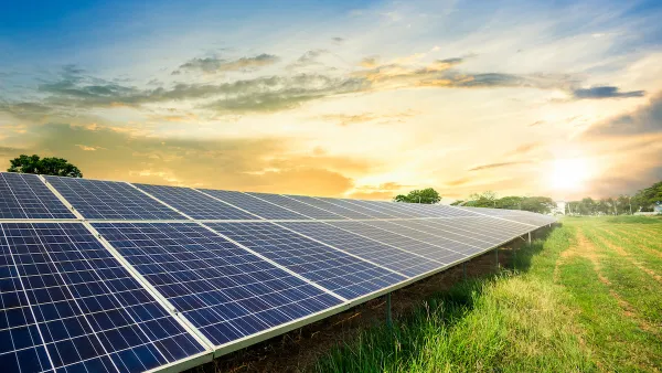 Photovoltainc solar panels in green grass field.