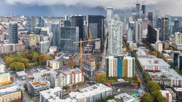 View of downtown Seattle with construction cranes and cloudy sky as seen from top of Space Needle.