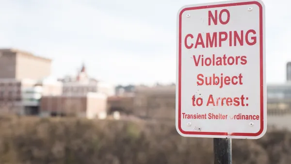 Close-up of red and white "No camping - Violators subject to arrest" sign.
