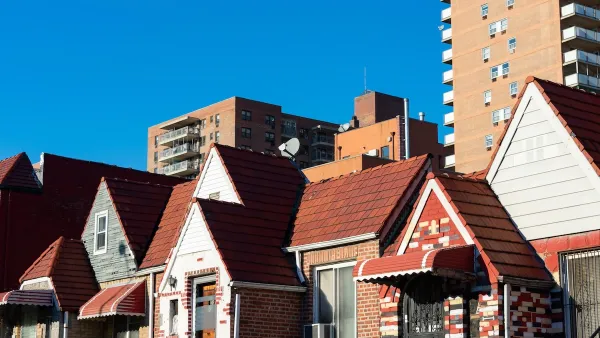 Row of old brick homes in Flushing, Queens, New York with high-rise buildings in background.