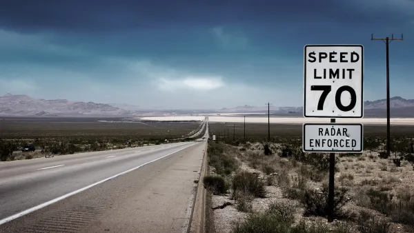 70 mph speed limit sign with bullet holes on southwestern highway with desert mountains in background.