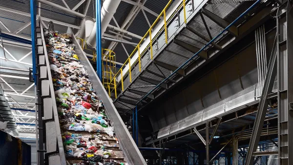 Conveyor belt in industrial recycling center with plastic materials.
