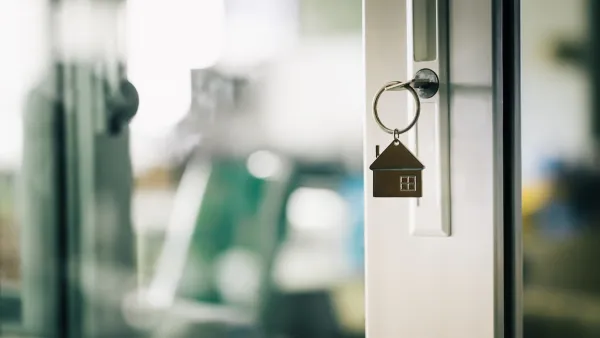 Close-up of house-shaped keychain in front door of home.