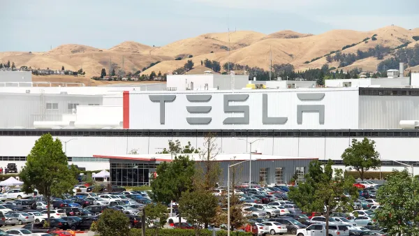 Tesla factory in Fremont, California with dry hills in background.
