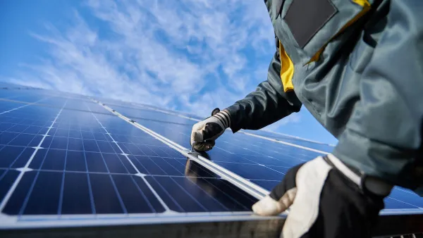 Close-up of technician wearing gloves installing photovoltaic solar panel.