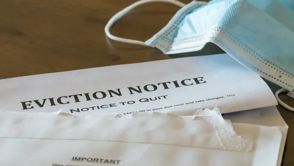 Eviction notice on table with surgical face mask lying next to it.