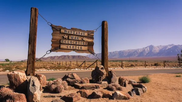 Sign for Manzanar War Relocation Center WWI-era internment camp in California with Sierra Nevada mountains in background.