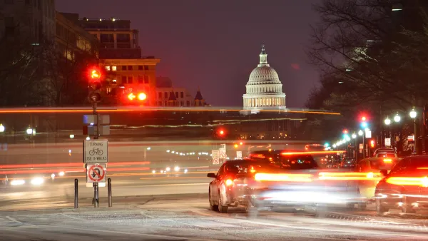 View of U.S capitol dome at night with blurred traffic in foreground