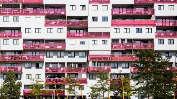 Multistory apartment building facade in Vienna, Austria with pink glass balconies.